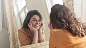 Femme souriante se regardant dans un miroir – introspection et expression de soi